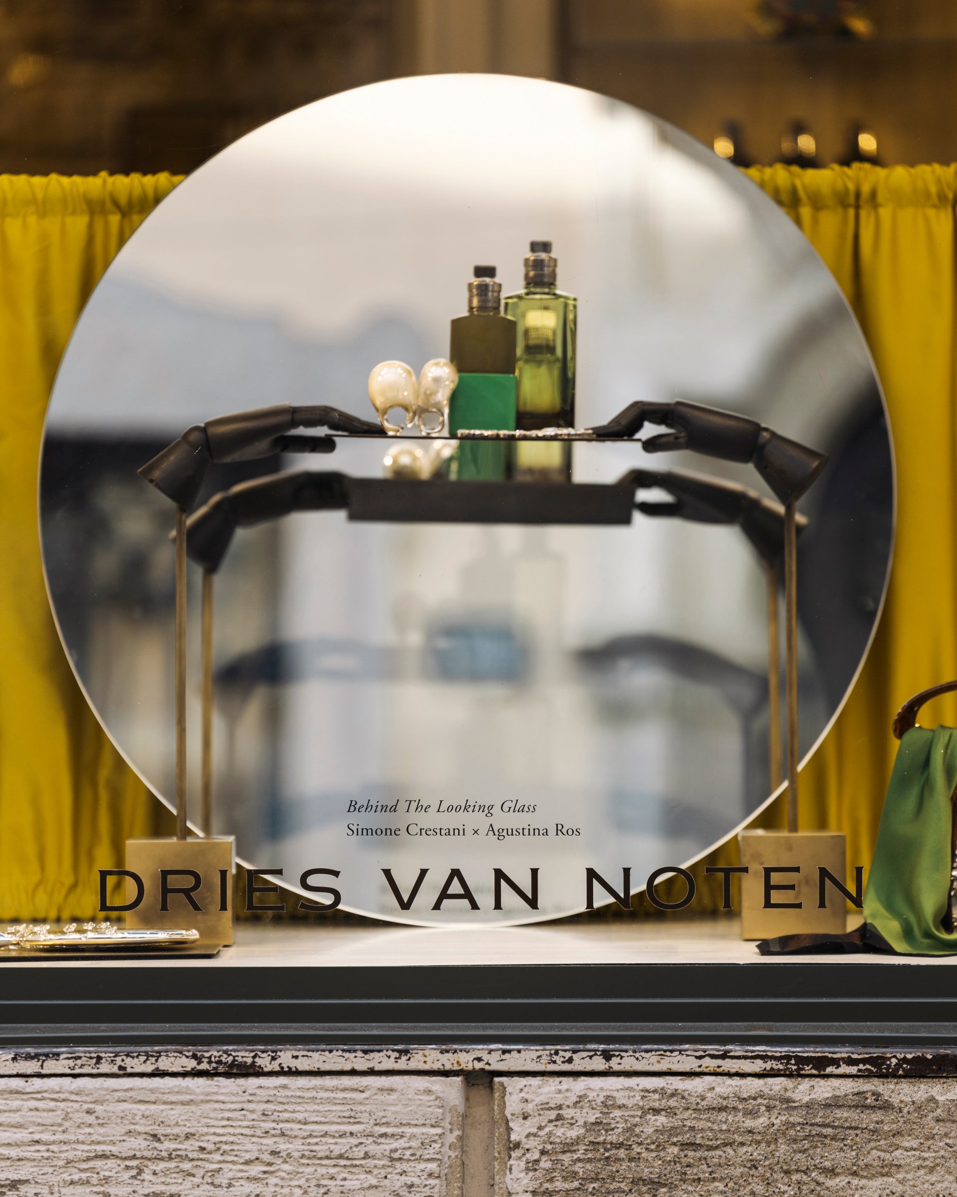 Dries Van Noten display with perfume bottles and a mirror