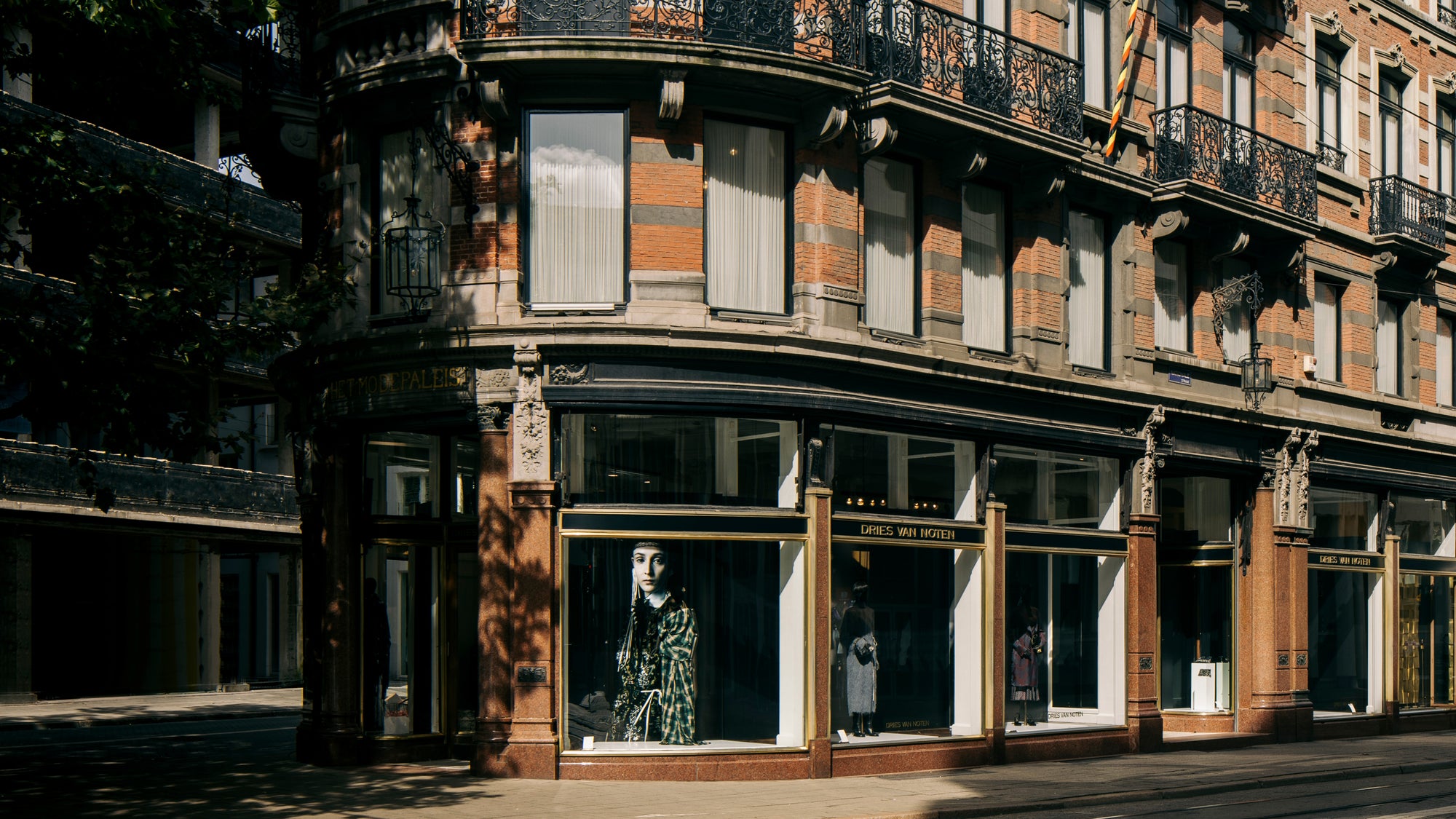Vintage building facade with a store front displaying mannequins.
