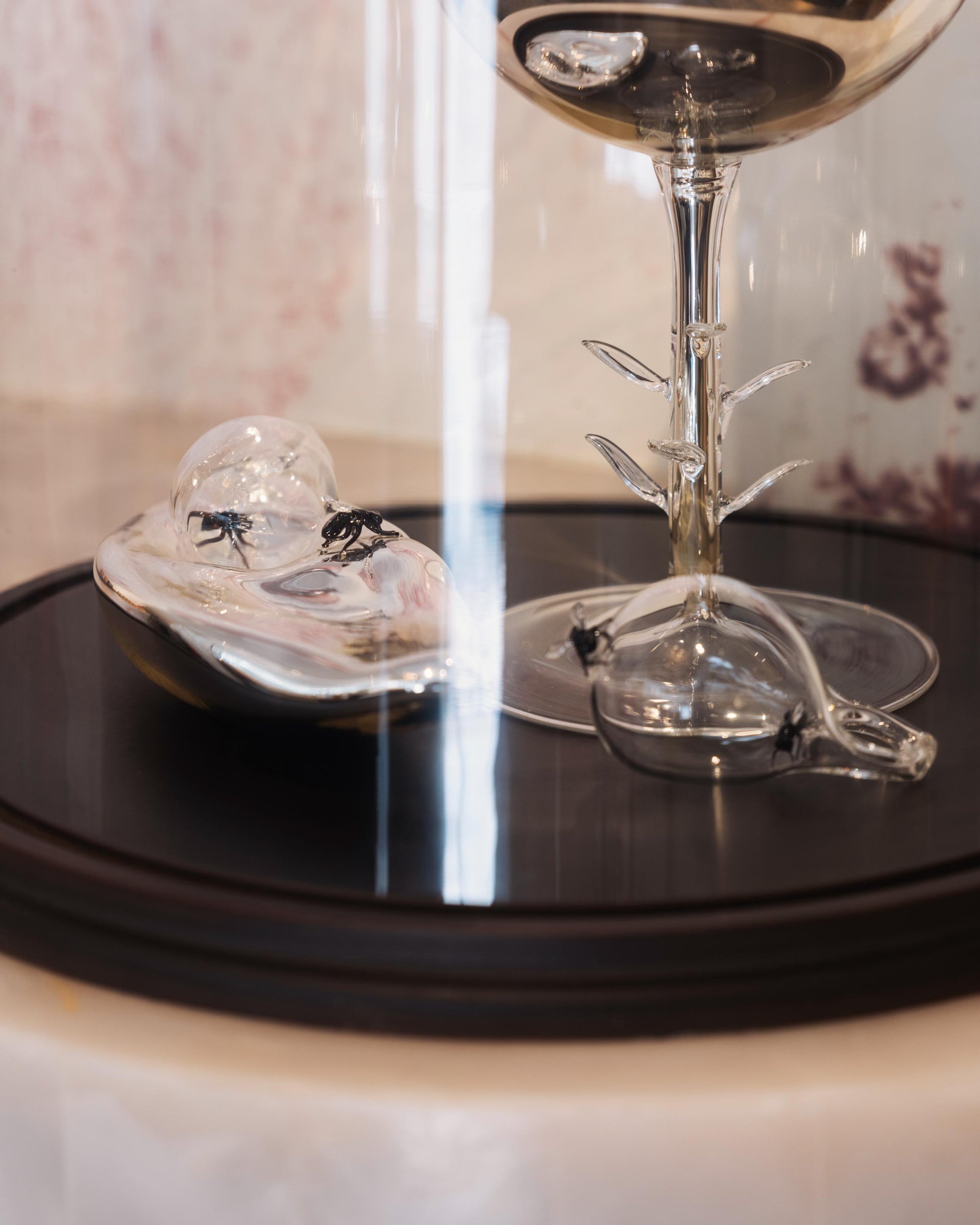 Clear glass objects on a black surface with a blurred background