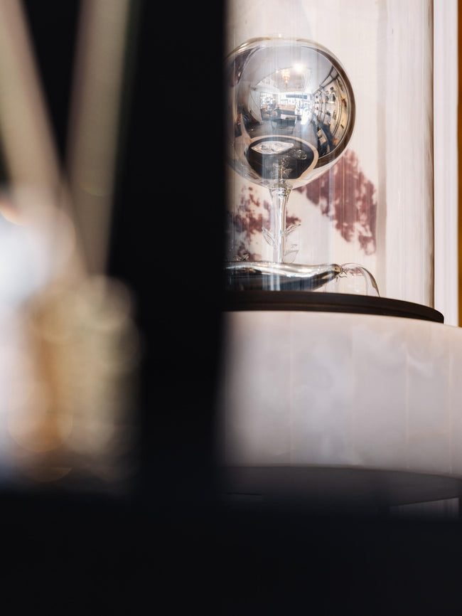 Close-up of a modern lamp with a glass shade on a blurred background