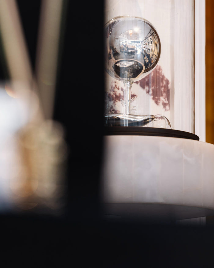 Close-up of a modern lamp with a glass shade on a blurred background