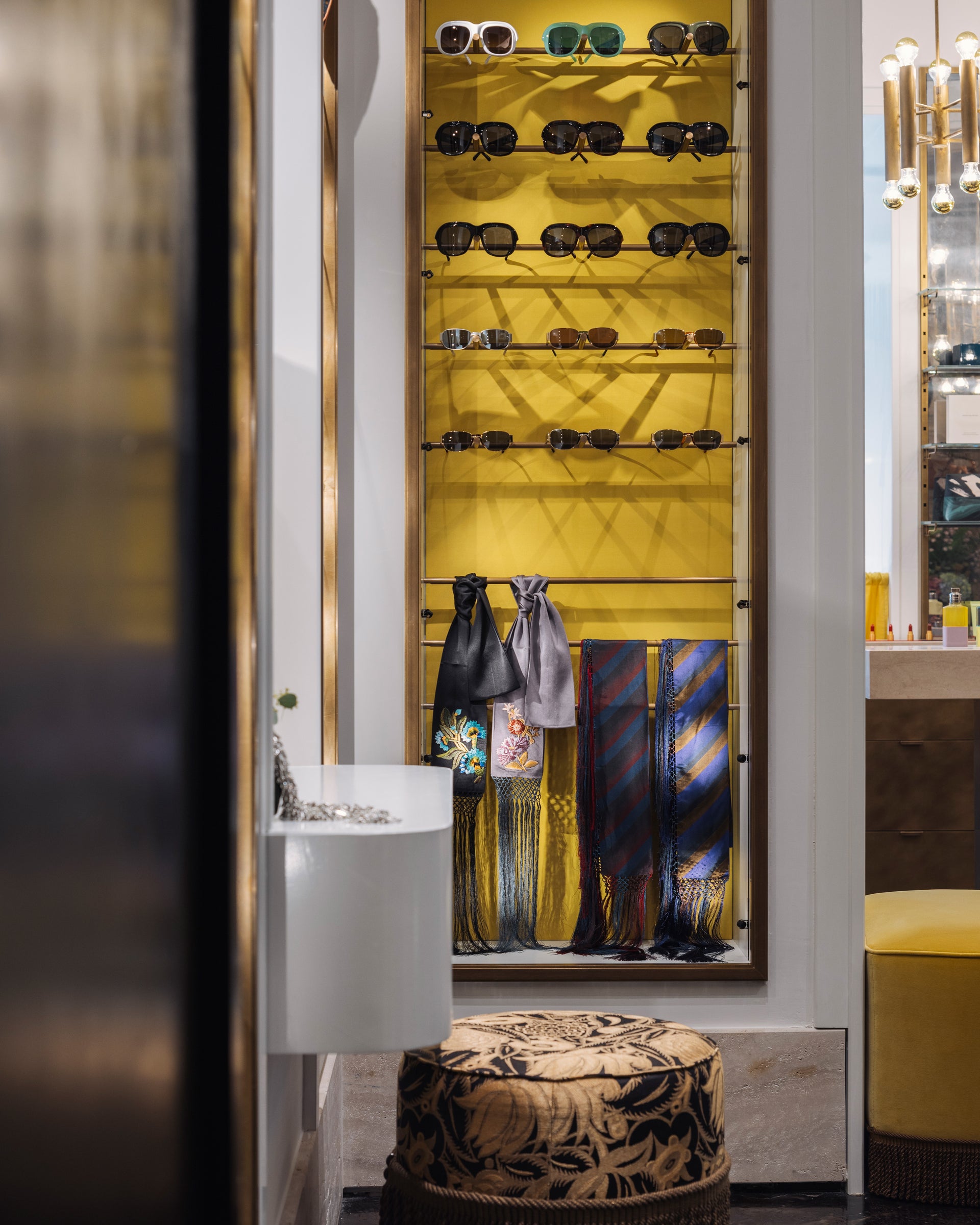 Shelving unit with sunglasses and ties in a stylish interior setting