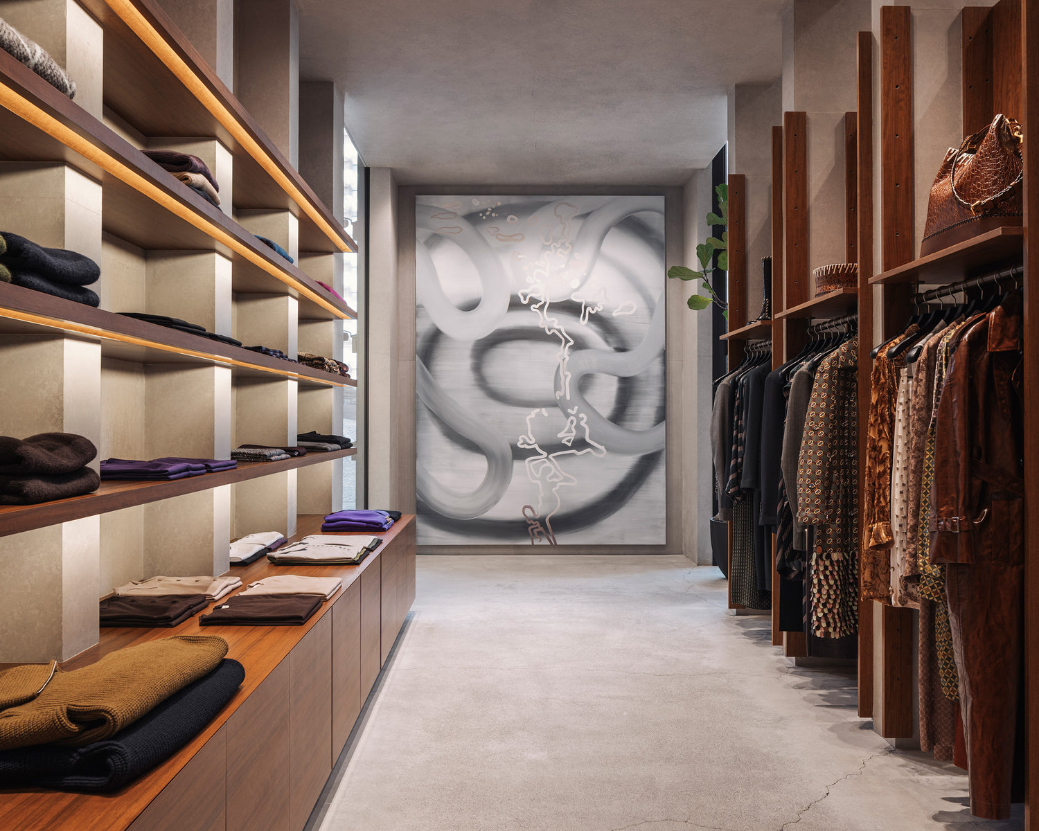 Modern walk-in closet with wooden shelves and clothing racks, featuring a large abstract painting on the wall.