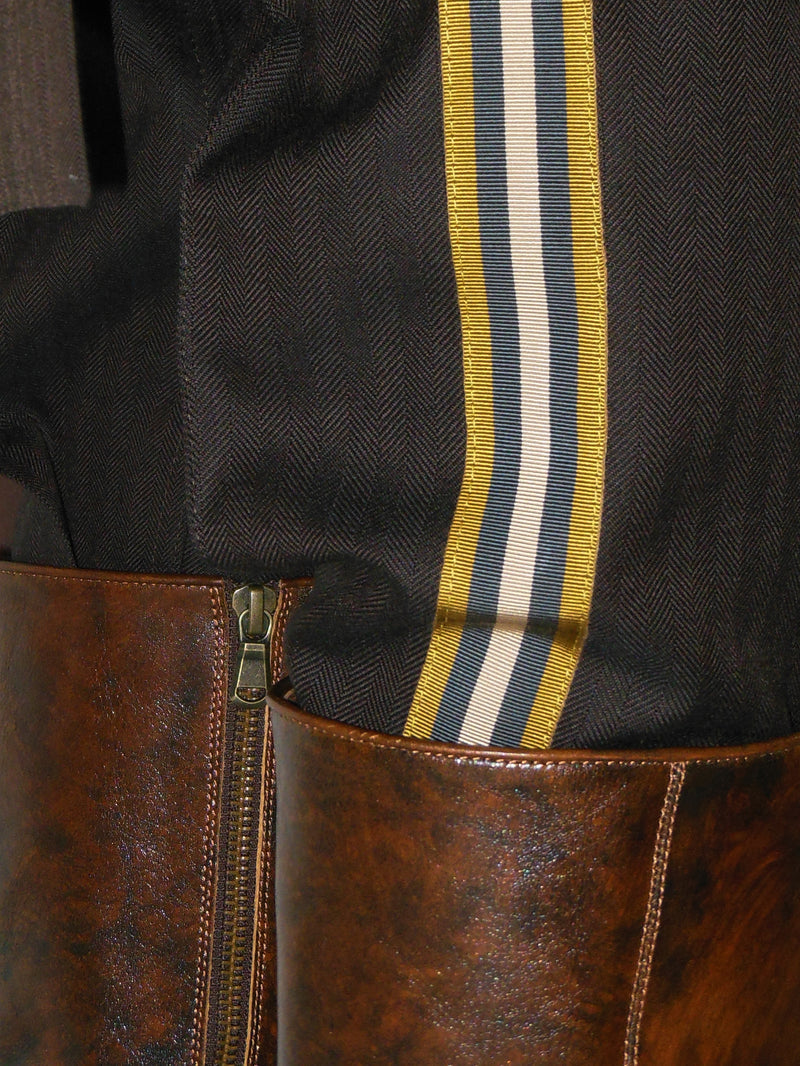 Close-up of a brown leather boot with a striped ribbon on a dark background