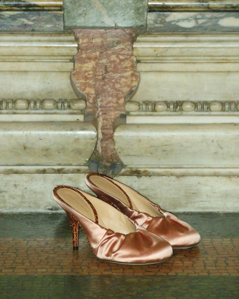 Pair of pink satin shoes on a marble floor