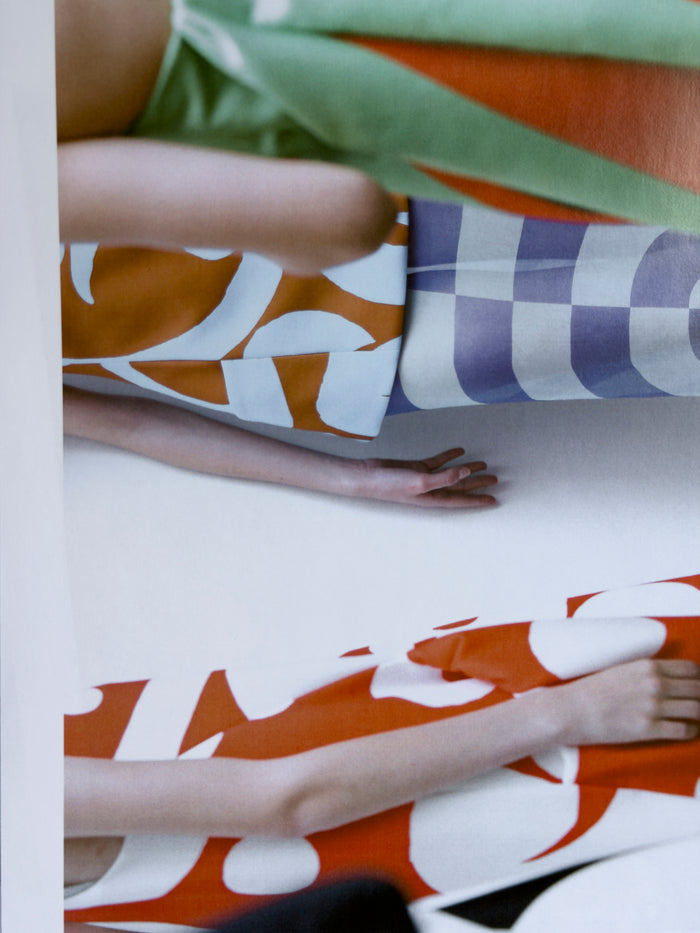 Person lying on a bed with patterned bedding