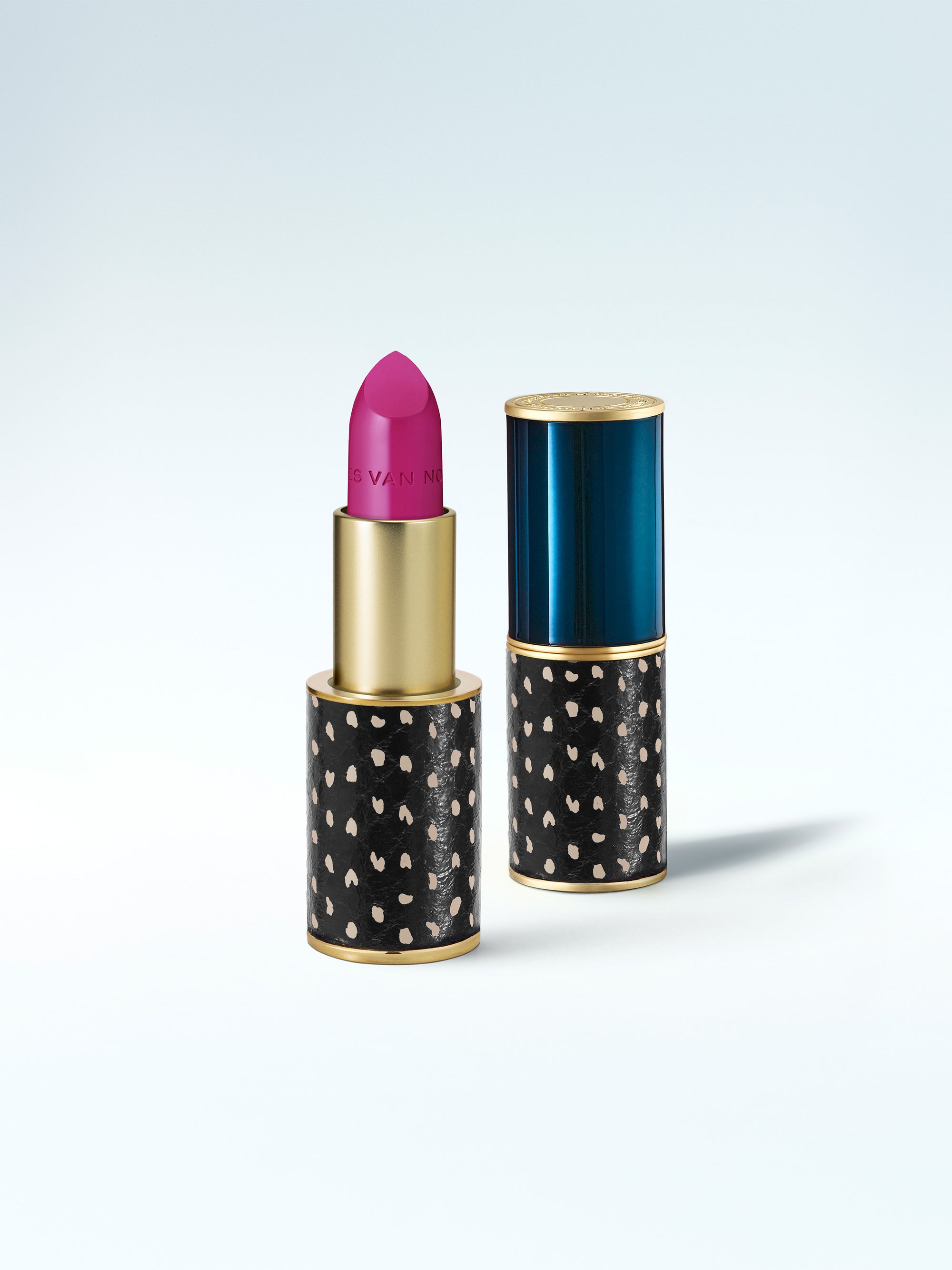 Lipstick with black case featuring white polka dots on a light gray background